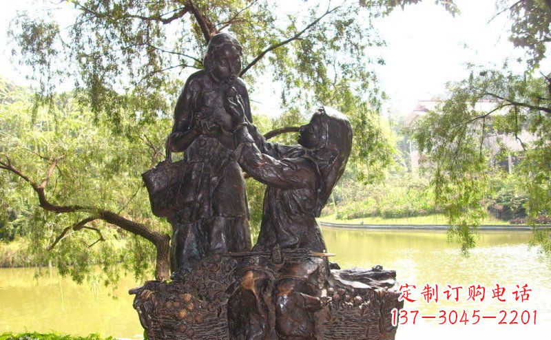 湖南温馨铜雕公园里喂母亲吃荔枝的女孩